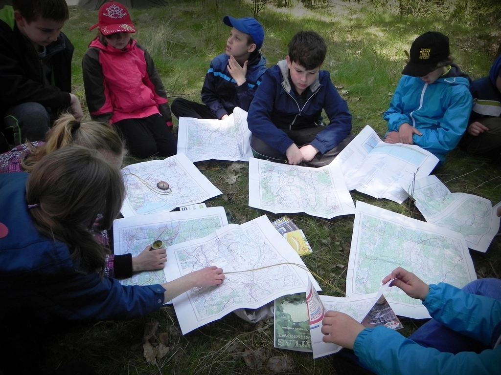 dzieci pracujace nad mapami podczas zielonej szkoly